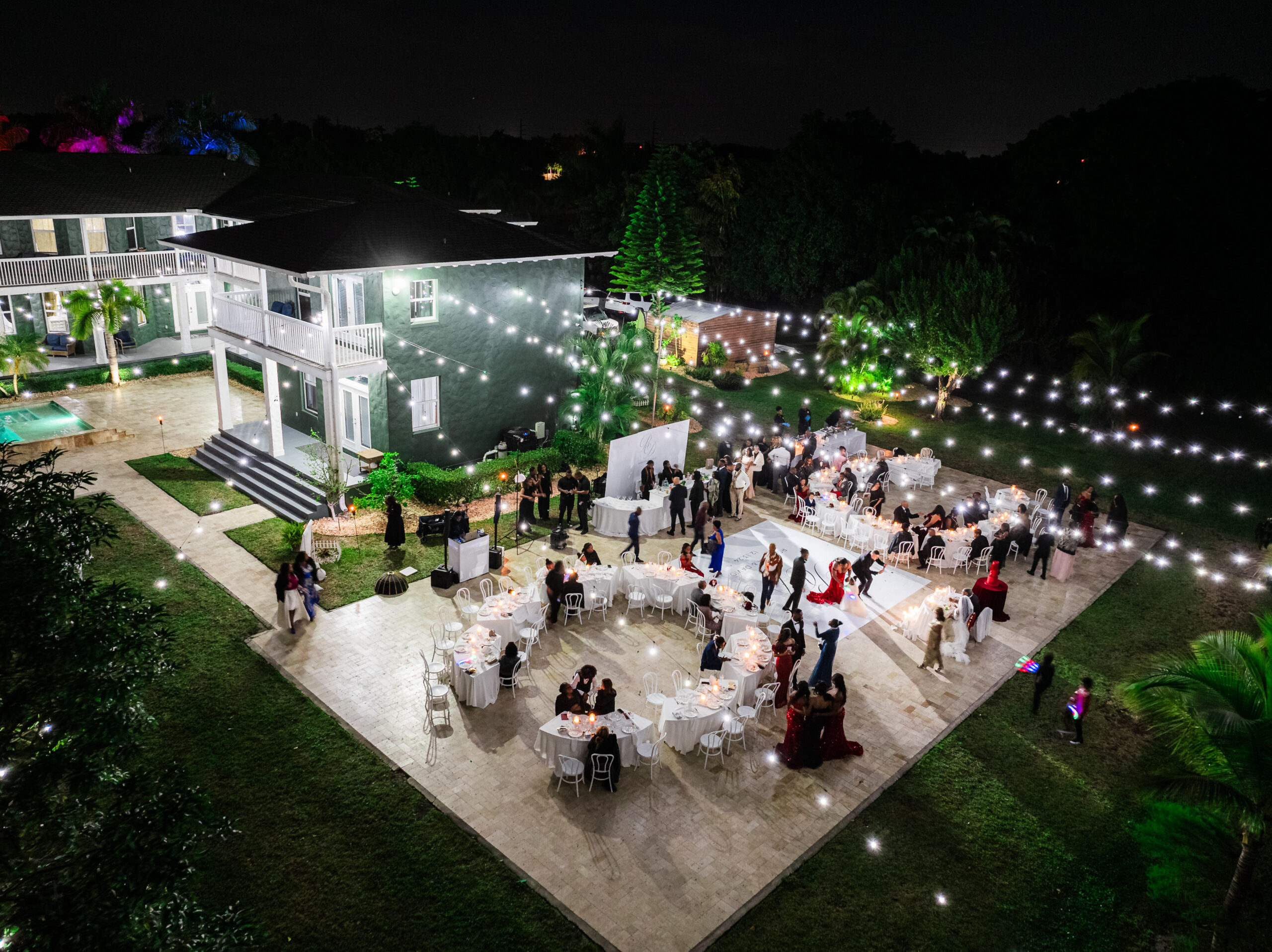 Night wedding reception with string lights at Saint Patrick Palace in Davie, Florida.